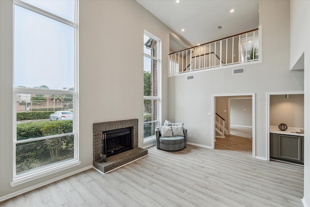 living room with plenty of natural light, light wood-style flooring, and stairs