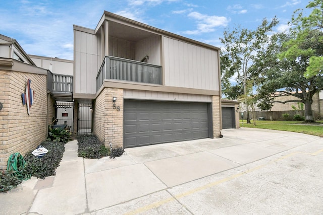 view of front of house featuring brick siding, concrete driveway, fence, a balcony, and a garage