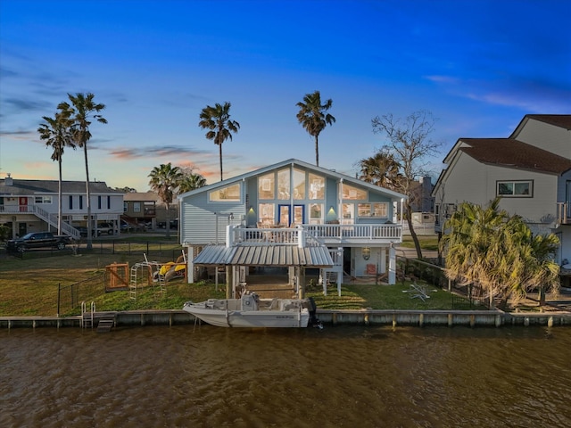 rear view of property featuring stairs and a deck with water view