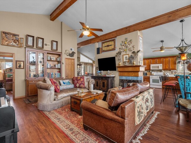 living area featuring high vaulted ceiling, beamed ceiling, wood finished floors, and a wealth of natural light