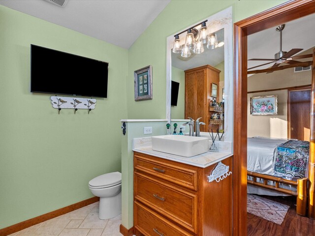 bathroom featuring toilet, vanity, a ceiling fan, baseboards, and tile patterned floors