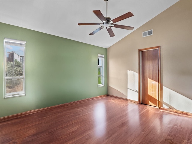 unfurnished room featuring lofted ceiling, visible vents, ceiling fan, and wood finished floors