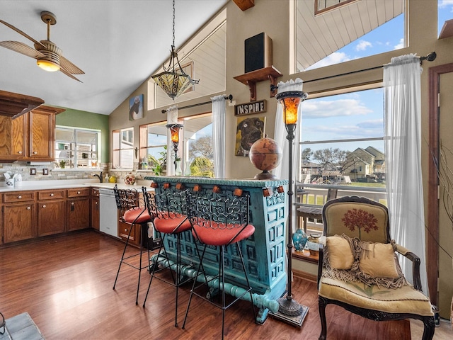 kitchen with plenty of natural light, white dishwasher, brown cabinets, and wood finished floors