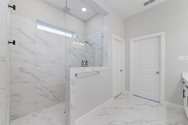 bathroom with marble finish floor, a marble finish shower, visible vents, vanity, and baseboards