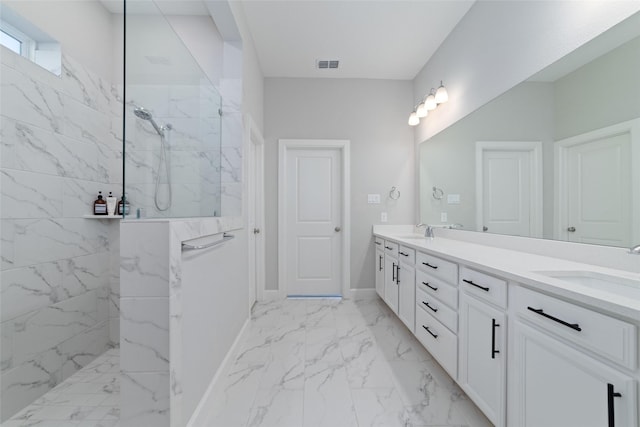 full bath featuring a marble finish shower, double vanity, a sink, and visible vents