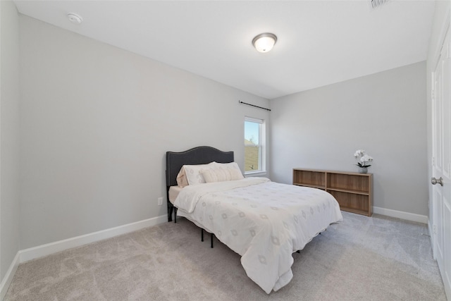 bedroom featuring light carpet and baseboards