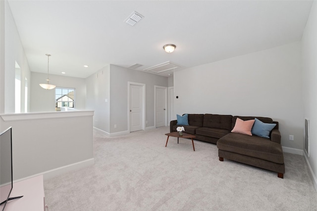 living room with light carpet, visible vents, attic access, and baseboards