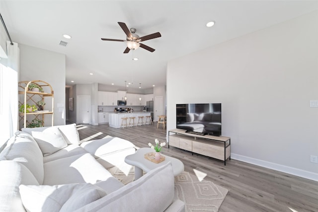 living area featuring light wood-style flooring, visible vents, and recessed lighting