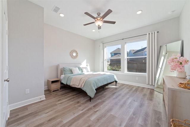 bedroom with light wood-style floors, visible vents, and baseboards