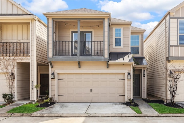 townhome / multi-family property featuring a garage, concrete driveway, a balcony, a standing seam roof, and board and batten siding