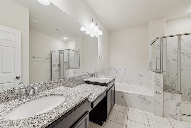 bathroom with a sink, a marble finish shower, and a bath