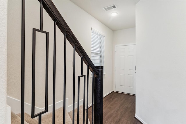 stairs featuring wood finished floors, visible vents, and baseboards