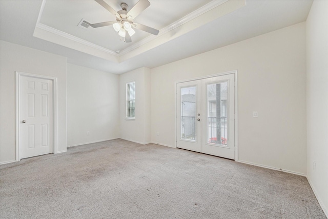 empty room with ceiling fan, light colored carpet, french doors, a raised ceiling, and crown molding