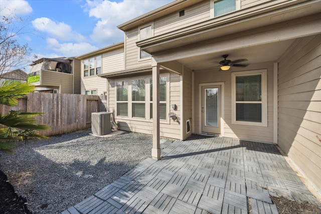 wooden deck with cooling unit, ceiling fan, fence, and a patio