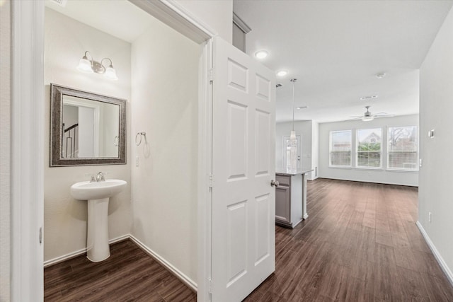 bathroom with a ceiling fan, a sink, baseboards, and wood finished floors