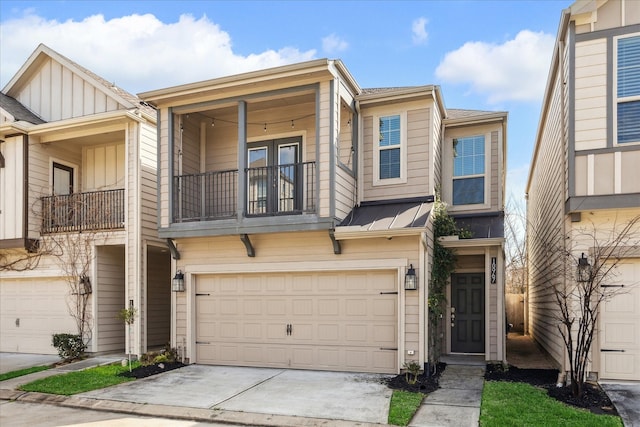 multi unit property featuring concrete driveway, an attached garage, board and batten siding, a standing seam roof, and a balcony