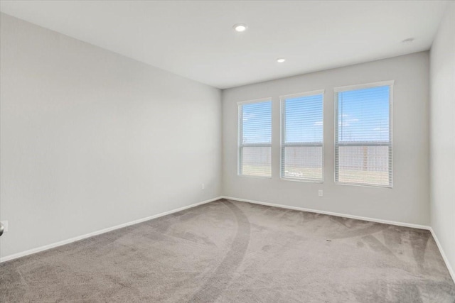 carpeted spare room featuring recessed lighting and baseboards