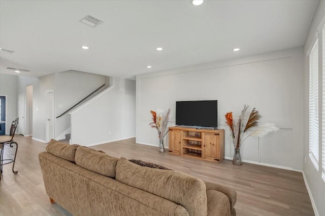 living room featuring recessed lighting, visible vents, wood finished floors, baseboards, and stairs