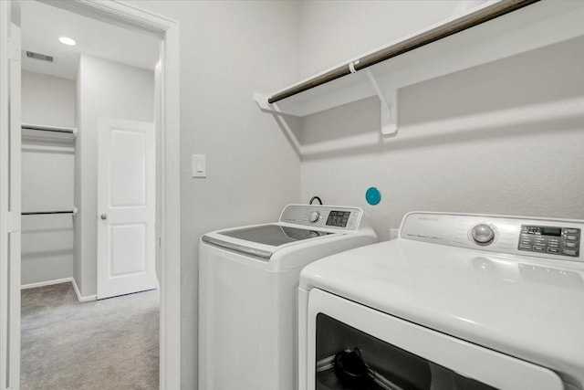 washroom featuring washing machine and dryer, light colored carpet, laundry area, visible vents, and baseboards