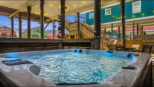 view of pool featuring stairs and a hot tub