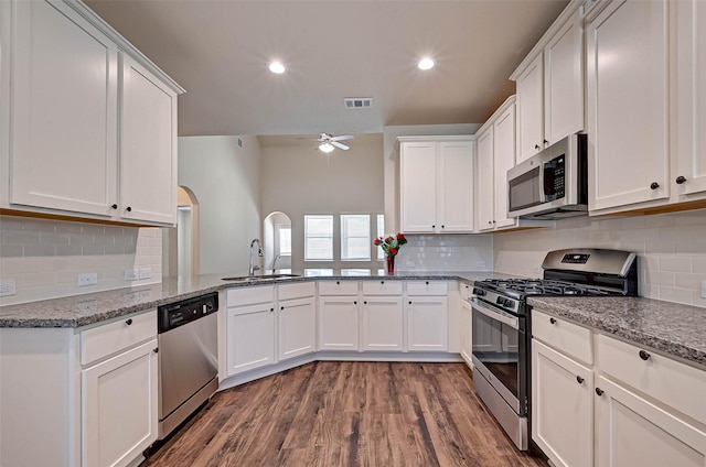 kitchen with light stone countertops, white cabinetry, visible vents, and stainless steel appliances