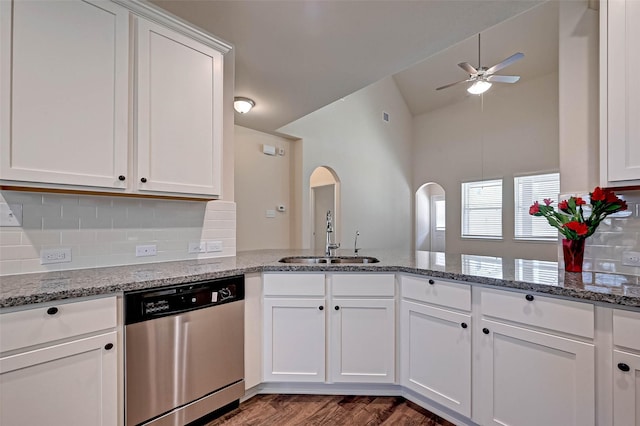 kitchen with decorative backsplash, stainless steel dishwasher, white cabinets, a sink, and a peninsula