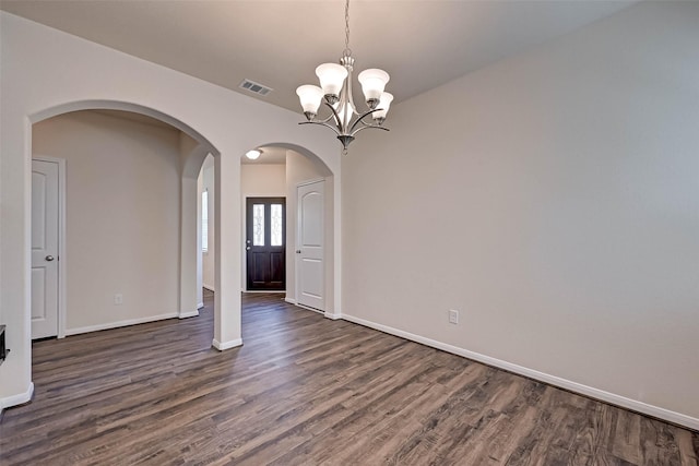 interior space with a chandelier, arched walkways, dark wood-style flooring, visible vents, and baseboards