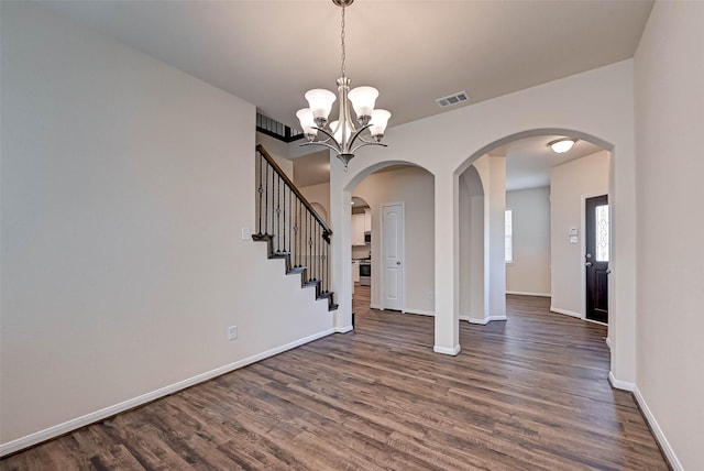 foyer with baseboards, visible vents, arched walkways, and dark wood-type flooring