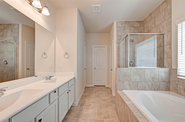 bathroom featuring a bath, a stall shower, visible vents, and a sink