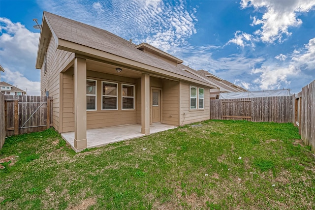 rear view of property with a patio area, a fenced backyard, and a yard