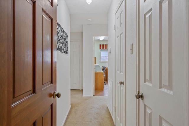 hallway featuring light colored carpet