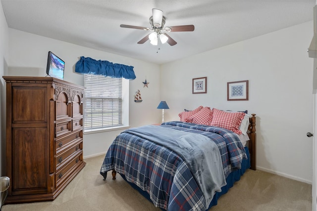 bedroom with ceiling fan, baseboards, and light colored carpet