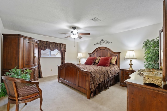 bedroom featuring a textured ceiling, light colored carpet, a ceiling fan, baseboards, and visible vents