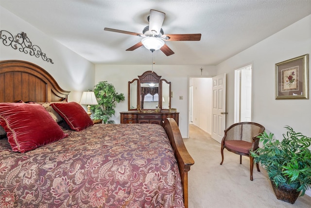 bedroom featuring light carpet, ceiling fan, and a textured ceiling