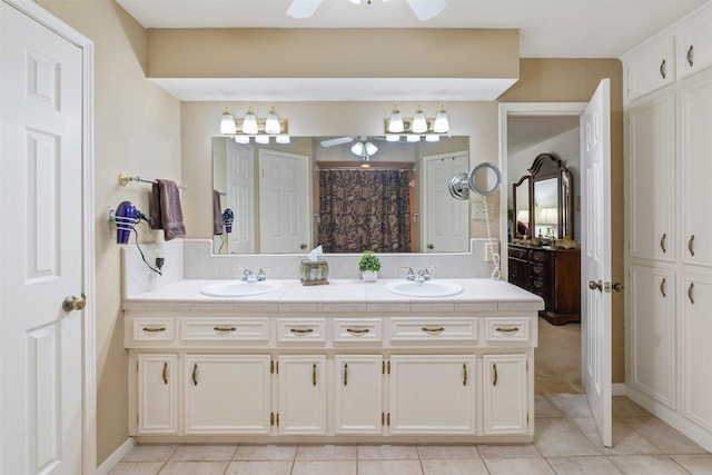 full bathroom with ceiling fan, double vanity, a sink, and tile patterned floors