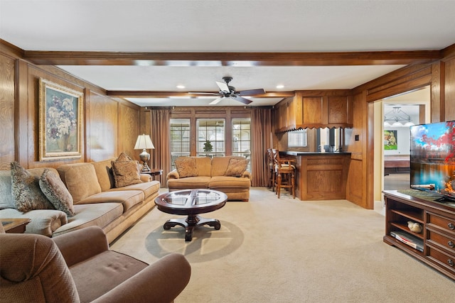 living area with beam ceiling, recessed lighting, light colored carpet, a ceiling fan, and wooden walls