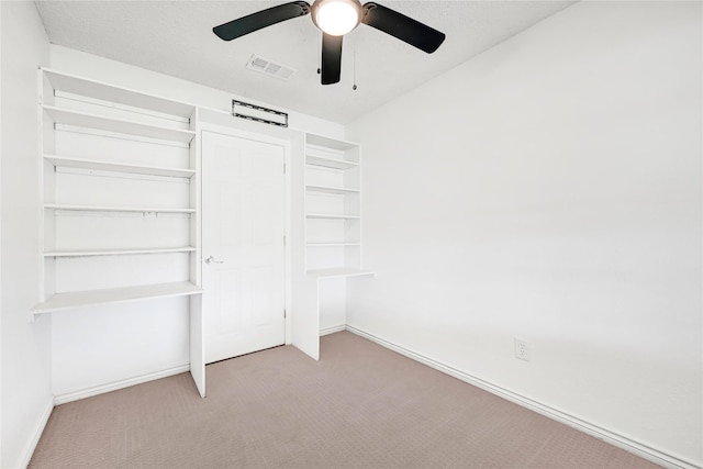 unfurnished bedroom with a ceiling fan, light colored carpet, visible vents, and baseboards