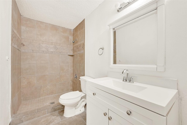 full bathroom with a textured ceiling, a stall shower, vanity, and toilet