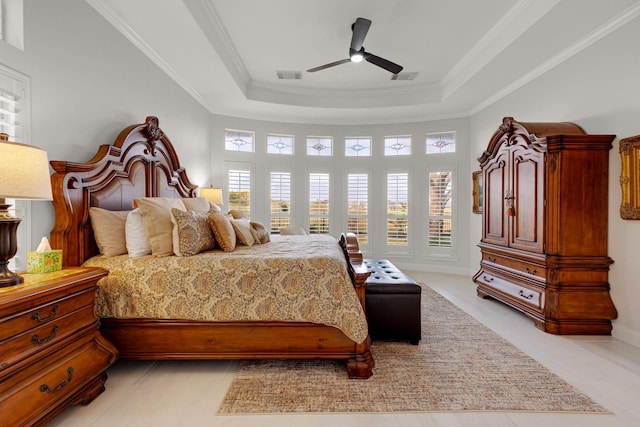 bedroom with ceiling fan, a tray ceiling, visible vents, and crown molding