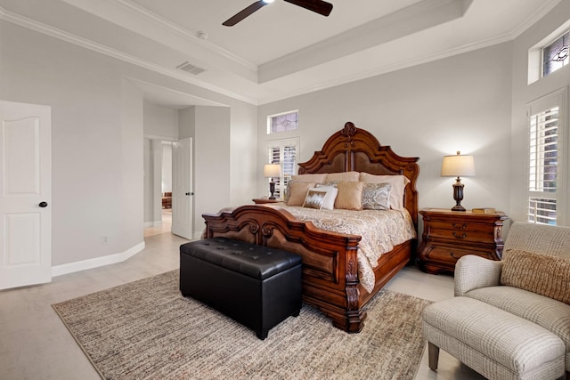 bedroom featuring baseboards, a raised ceiling, visible vents, and crown molding