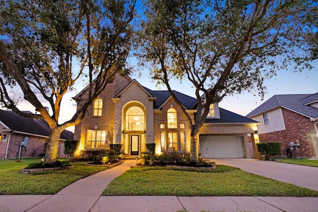 traditional home with concrete driveway, brick siding, a front lawn, and an attached garage