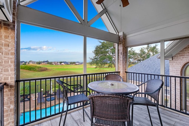 sunroom / solarium featuring vaulted ceiling and a ceiling fan