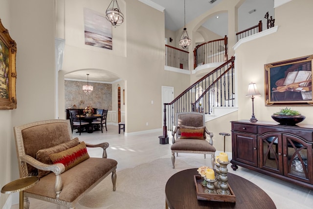 living room featuring arched walkways, crown molding, a high ceiling, a chandelier, and stairs