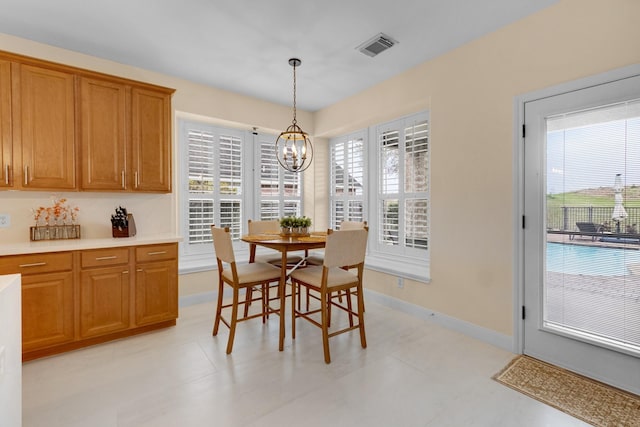 dining area featuring baseboards, plenty of natural light, visible vents, and a notable chandelier