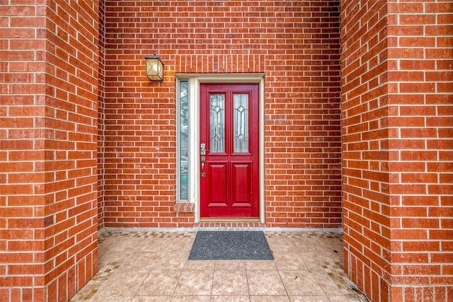 doorway to property featuring brick siding