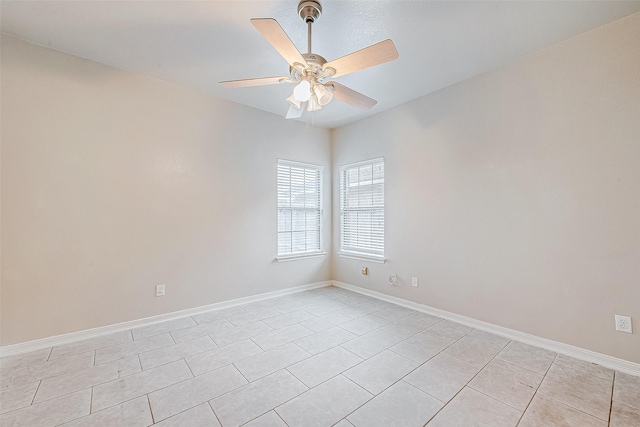 spare room with baseboards, a ceiling fan, and light tile patterned flooring