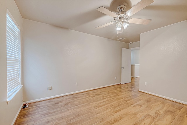 unfurnished room with baseboards, visible vents, a ceiling fan, and light wood-style floors