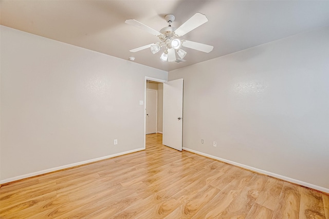 empty room featuring light wood-type flooring, visible vents, ceiling fan, and baseboards