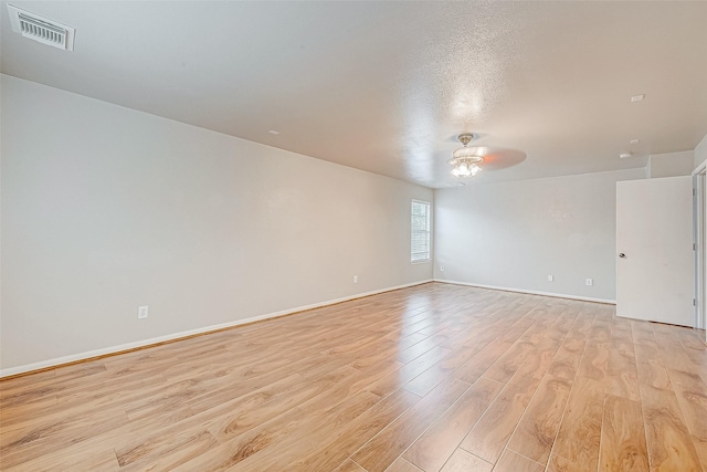 empty room featuring baseboards, visible vents, ceiling fan, and light wood finished floors