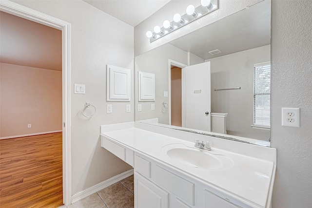 bathroom with visible vents, vanity, baseboards, and tile patterned floors